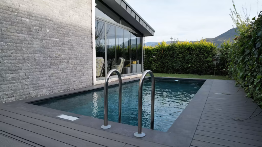 Tamamlanmış villa havuzu uygulaması – koyu seramik görünümlü kaplama ve kompozit deck